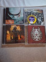 Front covers of four Disturbed CDs