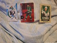 Front view of three Miro Heiskanen hockey cards displayed side by side on fabric background