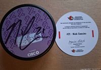 Autographed purple Hockey Fights Cancer puck with accompanying certificate of authenticity card