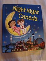 Front cover showing title, characters on crescent moon and Canadian skyline