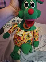 Front close-up of Polkaroo plush showing facial features and patterned tunic