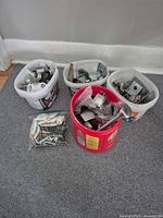 Four plastic tubs and zipper bag containing assorted hardware parts