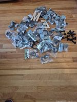 Pile of packaged black plastic characters and loose wood letters on floor