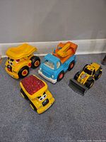 Group shot of four CAT plastic toy vehicles
