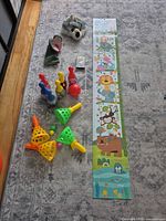 All items laid out on rug: scoop set, bowling set, wolf puppet, height chart, cassette