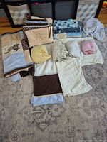 All pieces laid out: bumper, quilts, sheets, blanket, skirt
