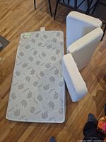 Crib mattress showing elephant pattern and two foam wedges