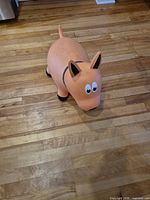 Top front view of orange dog-shaped hopper showing overall form and wear