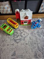 Group shot of barn, bus, garbage truck, airplane on rug