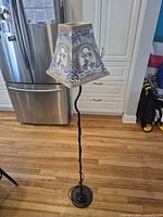 Entire floor lamp showing black metal base, curved pole, Jack Daniels shade, cord at base