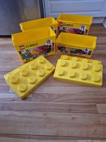 Four yellow LEGO Classic storage tubs with lids displayed upright