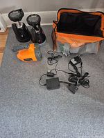 Group shot of three spotlights, chargers, and carry bag