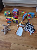 All items laid out: three plush hand puppets, three multicolor fabric cube blocks, one fabric accordion book