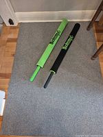 Green and black foam padded swords on grey mat