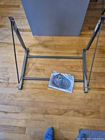 Rack unfolded laying on floor with printed manual for scale