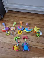 All seven clip-on stroller toys laid out on floor