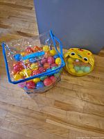 Clear tote filled with multicolor balls beside yellow mesh bag