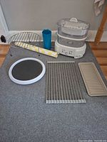 all components laid out including base, baskets, racks, trays, cup, mat, manual