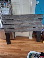 Front view of gray/black distressed engineered wood headboard with side legs