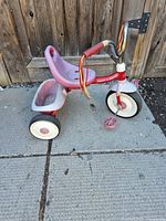 Side view of Radio Flyer toddler tricycle showing frame, seat, bin, tires