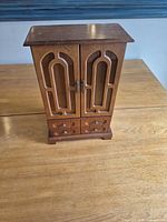 Front view closed showing walnut-tone jewelry armoire