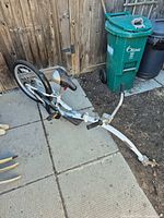 Full view of trail-a-bike on ground showing frame, wheel, hitch