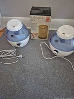Two Vicks humidifiers with cords and boxed GE/CGE air cleaner