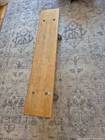 Top view of entire wooden bench seat showing wear and bolt holes