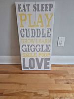 Front view of the white wooden vertical sign showing gray and yellow text