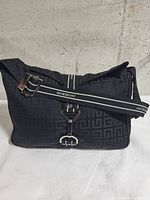 Front view of Givenchy monogram canvas bag showing buckle, strap and pattern