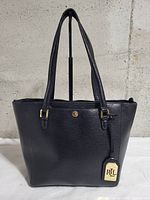 Front view of black leather tote with RL button and hangtag