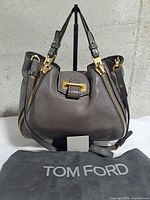 Front view of charcoal grey Tom Ford Sedgwick Zip Tote with dust bag and card