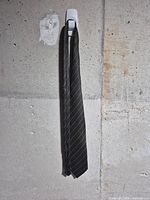 Front view of black patterned silk tie hanging straight
