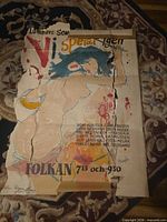 Full view of torn Swedish concert poster on rug