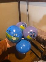 Four maraca heads showing blue and purple colors and floral motifs