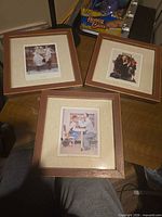 Three framed prints on table