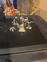 All six pewter miniatures grouped on black surface