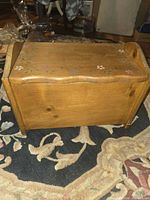front angled view of pine toy chest showing curved front and floral painting