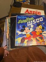 Stack of LPs topped by Mickey Mouse Disco, Annie visible beneath
