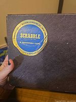 close-up of circular Scrabble seal on box lid