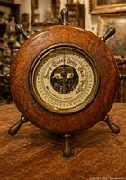 front view of wooden ship wheel barometer showing dial and brass spokes
