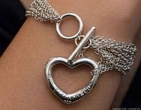 Necklace worn on wrist showing heart pendant and toggle