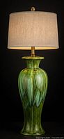 Full view of green drip glaze ceramic lamp with shade shown for scale