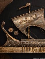 Close-up of sail, shields, and dragon-prow hammered copper detailing