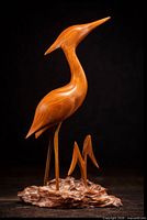 Full view of carved wooden bird sculpture facing right