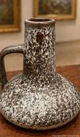 Full view of vase showing handle, neck, and drip glaze texture
