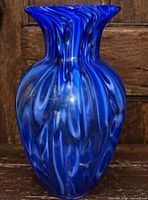 Front view of cobalt blue art glass vase showing white swirl pattern and flared rim