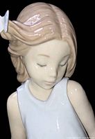 Close-up of figurine head showing butterfly in hair and facial detail