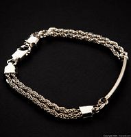 Entire bracelet coiled showing rope strands, bar accent and clasp
