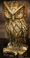 Front view of brass owl showing full form and patina